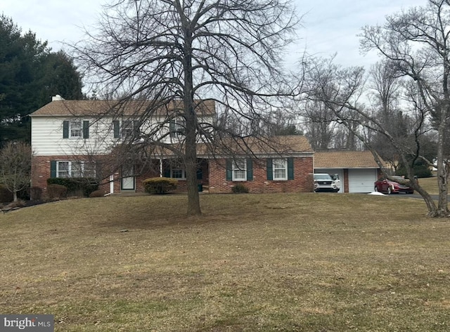 traditional-style house featuring a garage, a front yard, and brick siding