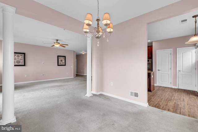 empty room with carpet floors, ornate columns, and visible vents