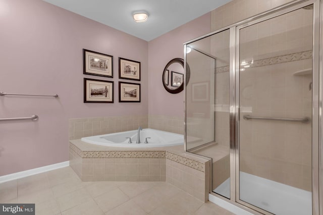 full bath featuring a stall shower, tile patterned flooring, a garden tub, and baseboards