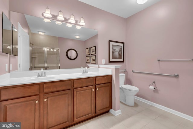 full bathroom featuring toilet, a sink, baseboards, a shower stall, and double vanity