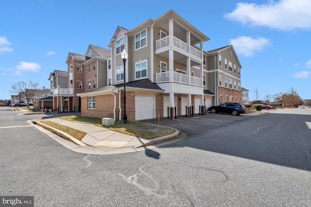 exterior space featuring an attached garage, a residential view, and central air condition unit