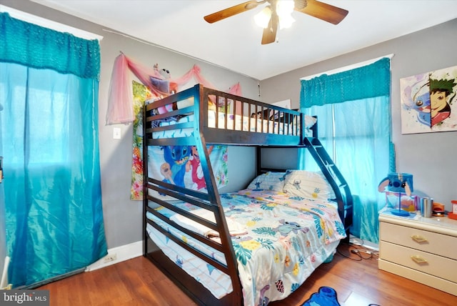 bedroom with multiple windows, hardwood / wood-style flooring, and ceiling fan