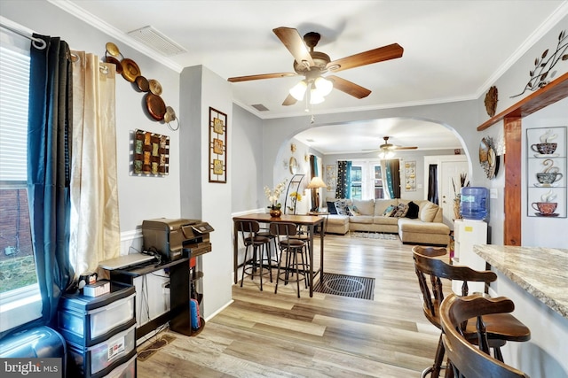 living room featuring crown molding, light hardwood / wood-style floors, and ceiling fan