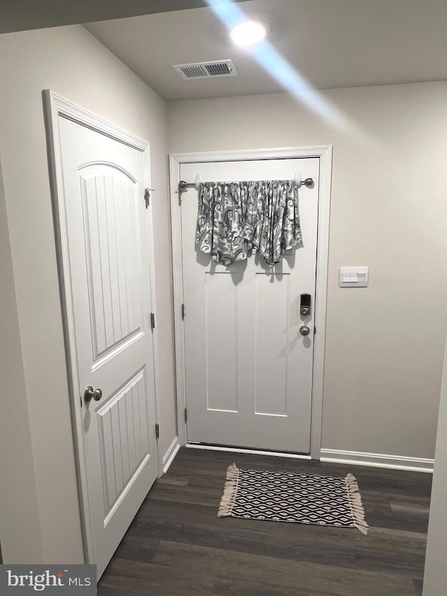 entryway with dark wood-style floors, baseboards, and visible vents