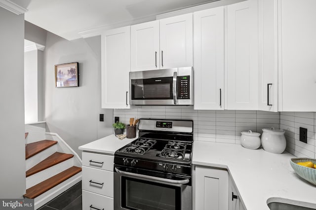 kitchen featuring white cabinets, appliances with stainless steel finishes, and tasteful backsplash