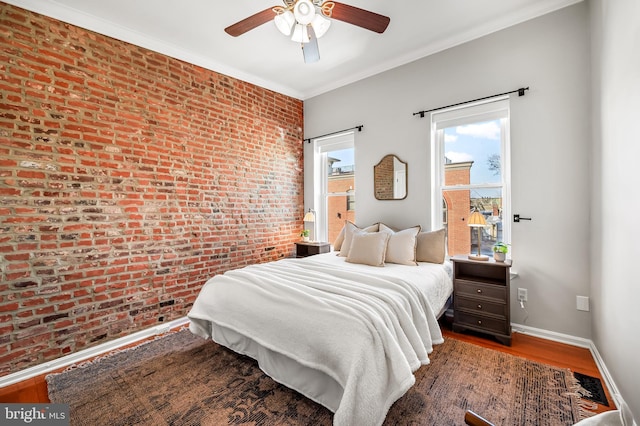 bedroom with ceiling fan, brick wall, crown molding, and wood-type flooring