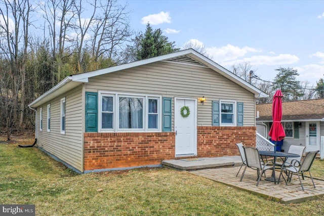 view of front of house with a patio and a front yard