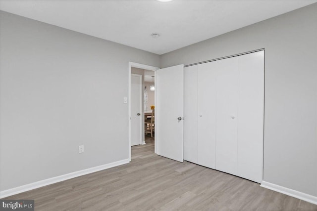 unfurnished bedroom featuring a closet and light wood-type flooring