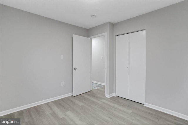 unfurnished bedroom with a closet and light wood-type flooring