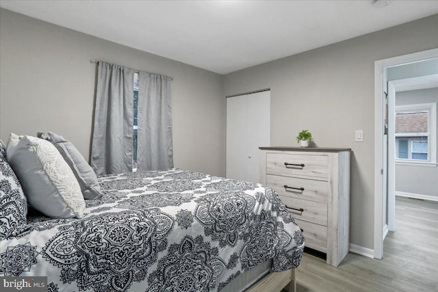 bedroom with a closet and light hardwood / wood-style flooring