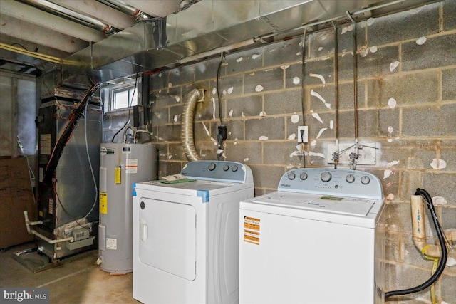 laundry area featuring water heater, heating unit, and washer and clothes dryer