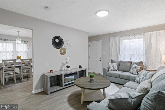 living room featuring light hardwood / wood-style floors and a textured ceiling