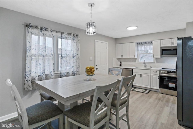 dining area featuring sink and light hardwood / wood-style flooring