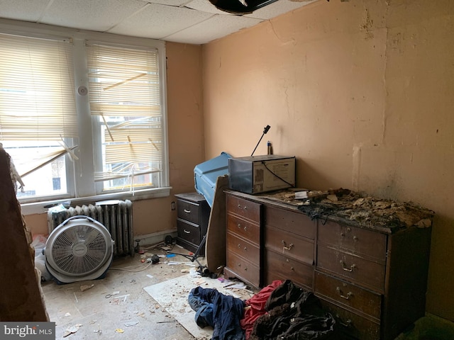 misc room featuring radiator and a paneled ceiling