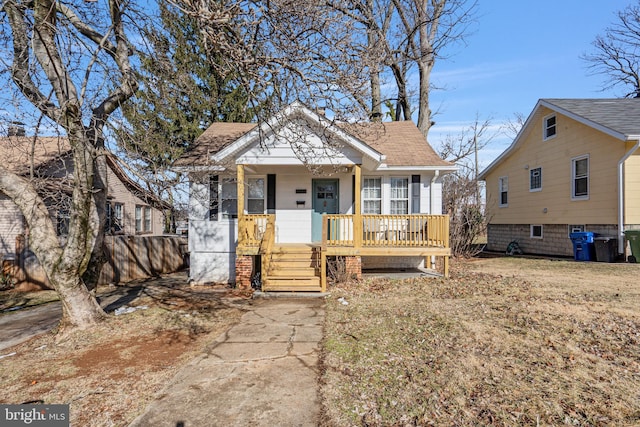 bungalow with a front lawn and covered porch