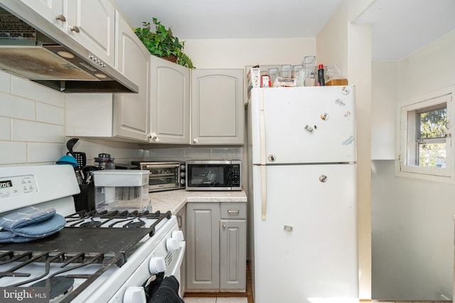 kitchen featuring white cabinetry, exhaust hood, backsplash, and white appliances