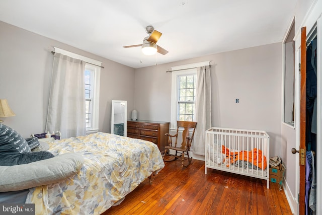 bedroom with dark hardwood / wood-style floors and ceiling fan