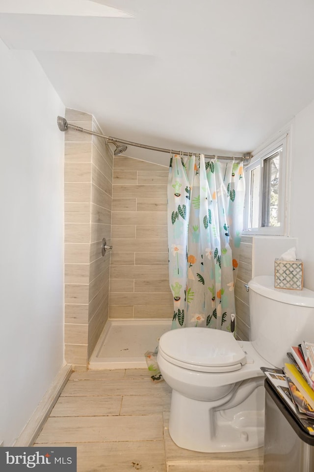 bathroom featuring curtained shower and toilet