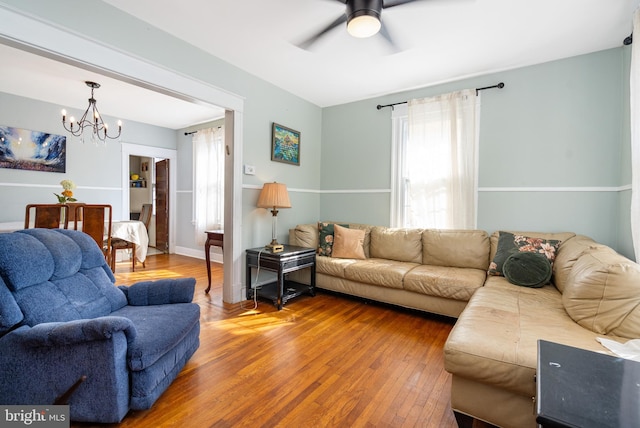 living room featuring hardwood / wood-style flooring and ceiling fan with notable chandelier