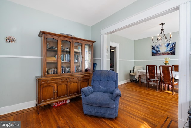 living area featuring dark hardwood / wood-style floors and a chandelier