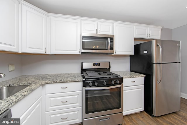 kitchen with sink, dark wood-type flooring, white cabinets, and stainless steel appliances