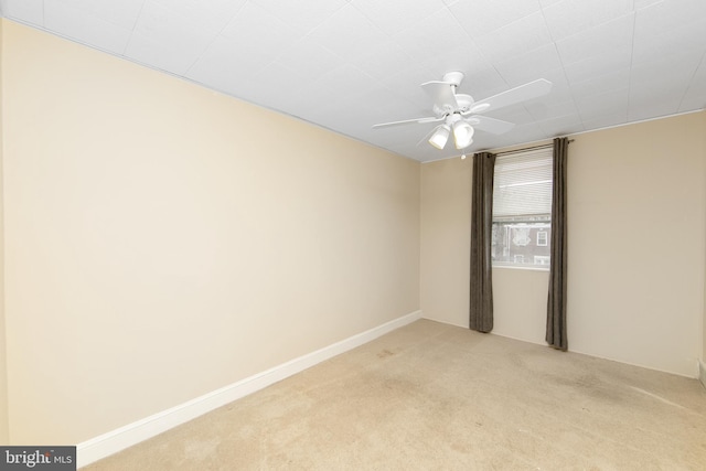 spare room featuring light carpet and ceiling fan