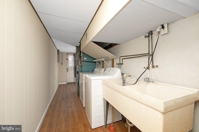 clothes washing area with hardwood / wood-style floors, sink, and washing machine and clothes dryer