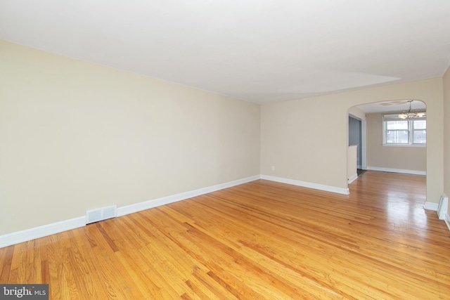 unfurnished room with hardwood / wood-style floors and a chandelier