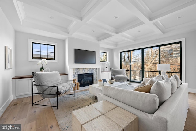 living room featuring beam ceiling, plenty of natural light, and light wood-type flooring