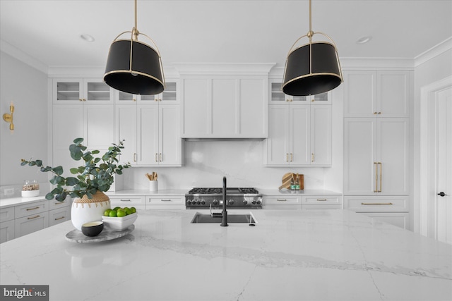 kitchen featuring decorative light fixtures, ornamental molding, and light stone countertops