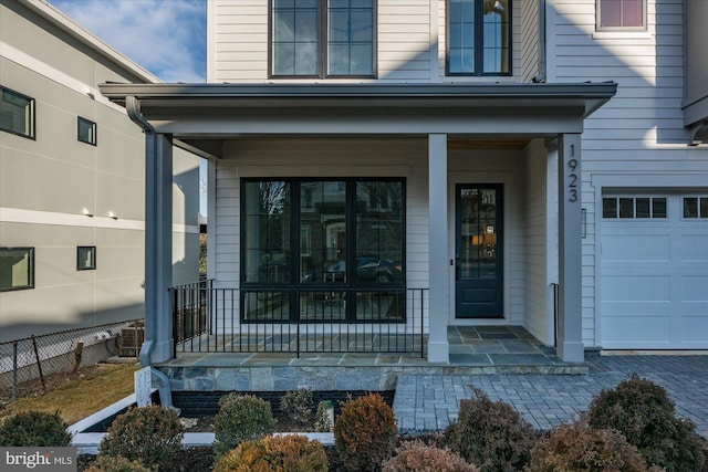 property entrance with a garage and covered porch