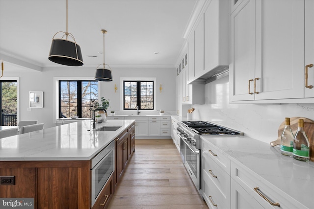 kitchen featuring a kitchen island with sink, sink, white cabinetry, and appliances with stainless steel finishes