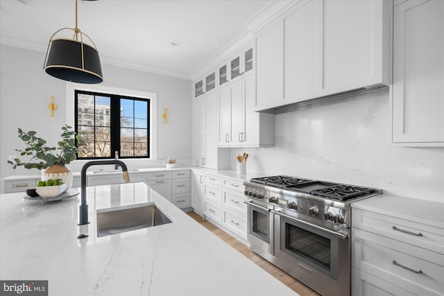 kitchen featuring sink, white cabinets, hanging light fixtures, double oven range, and light stone countertops