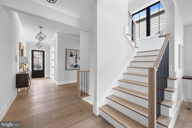 foyer entrance featuring ornamental molding and light wood-type flooring