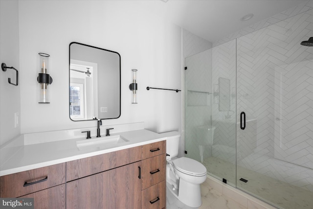 bathroom featuring vanity, a shower with shower door, and toilet