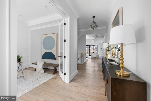 hallway featuring beam ceiling, crown molding, coffered ceiling, and light hardwood / wood-style floors