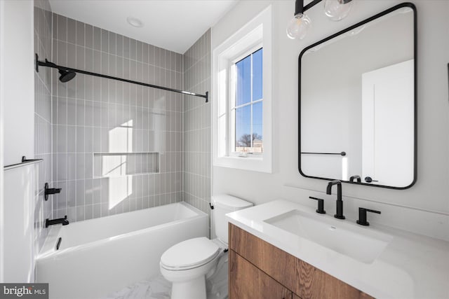 full bathroom with tiled shower / bath, vanity, and toilet