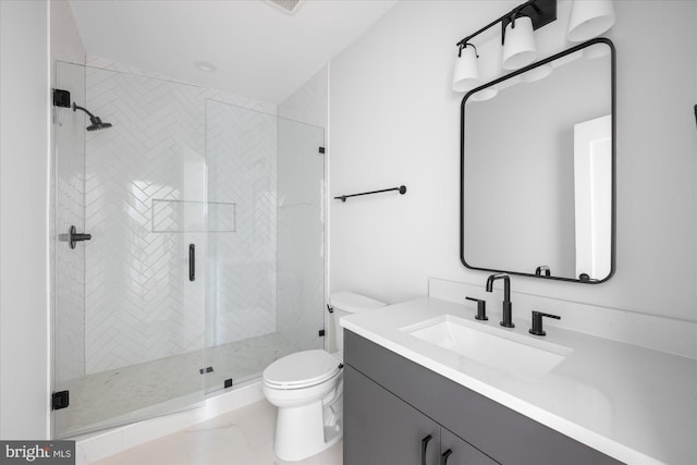 bathroom featuring vanity, a shower with door, and toilet