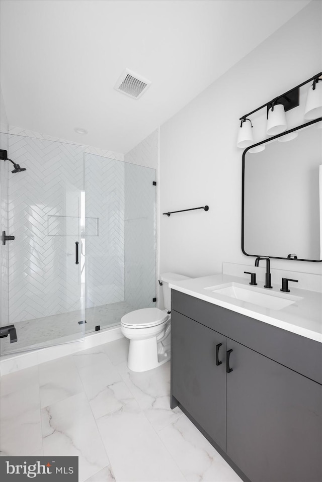 bathroom with vanity, a shower with shower door, and toilet