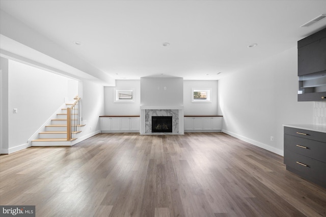 unfurnished living room with a premium fireplace and wood-type flooring