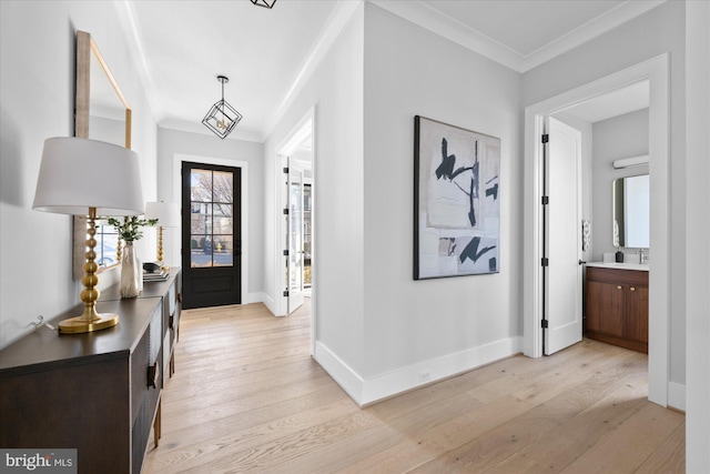 entrance foyer featuring crown molding, sink, and light wood-type flooring