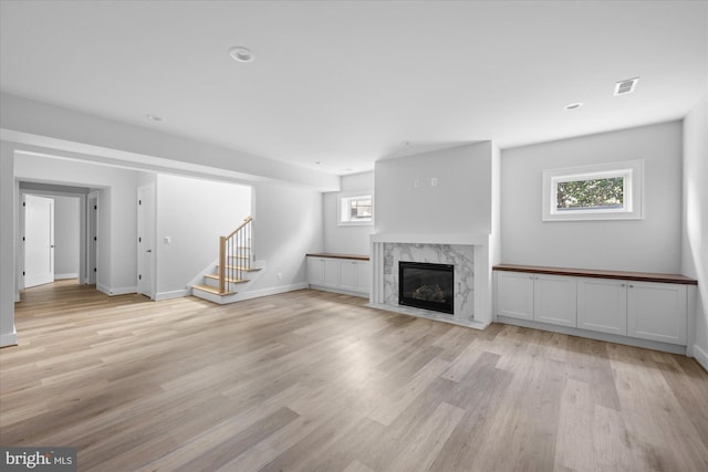 unfurnished living room featuring a fireplace and light hardwood / wood-style flooring