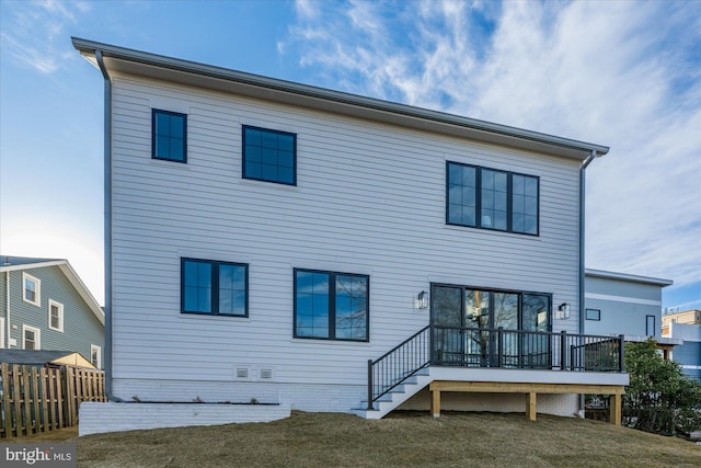 rear view of house with a deck and a lawn