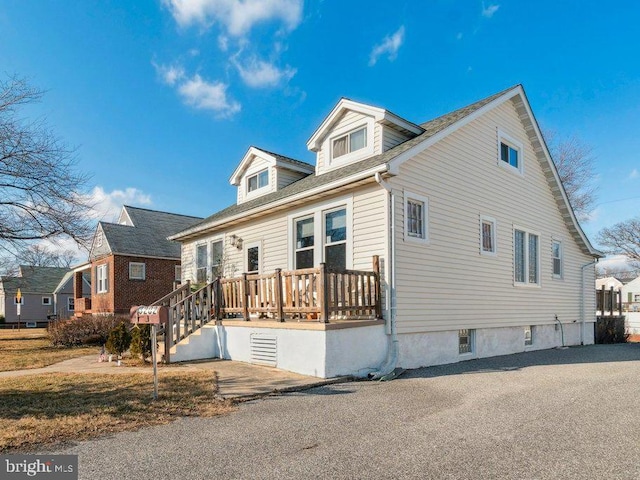 cape cod-style house featuring a wooden deck