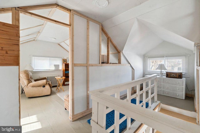 bedroom with lofted ceiling, radiator, and light hardwood / wood-style flooring