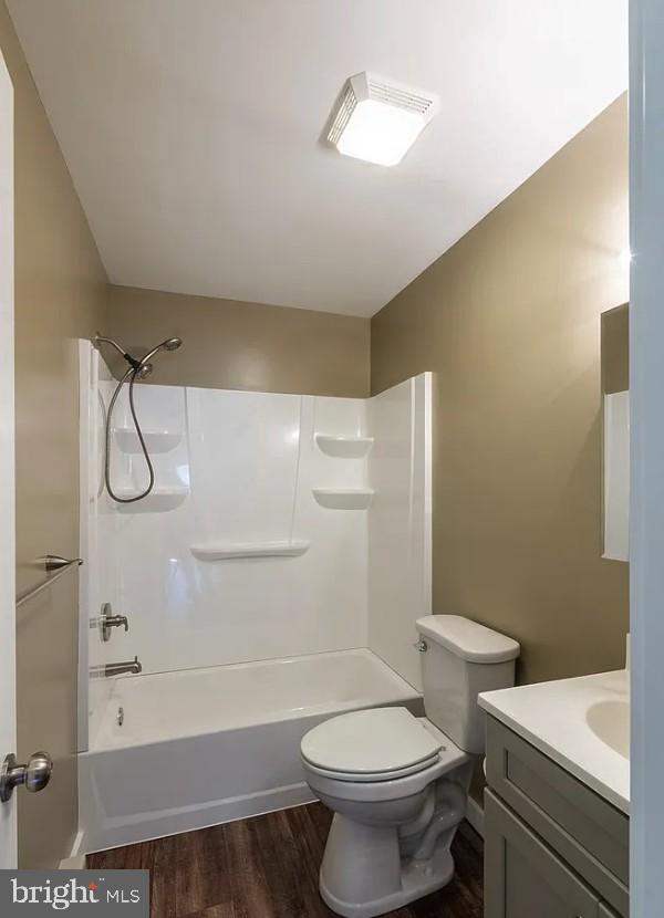 full bathroom featuring toilet, vanity, shower / washtub combination, and hardwood / wood-style floors