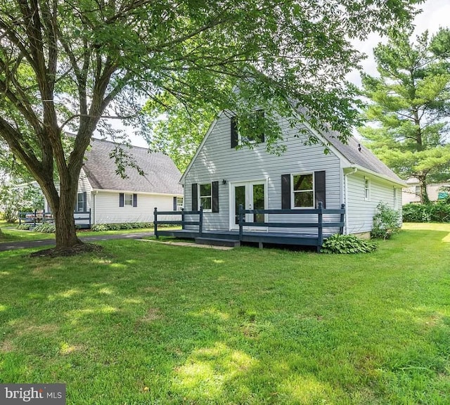 rear view of house with a yard and a wooden deck