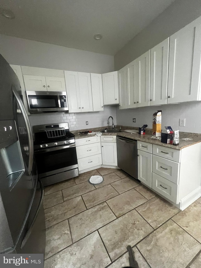 kitchen with white cabinetry, sink, tasteful backsplash, and stainless steel appliances