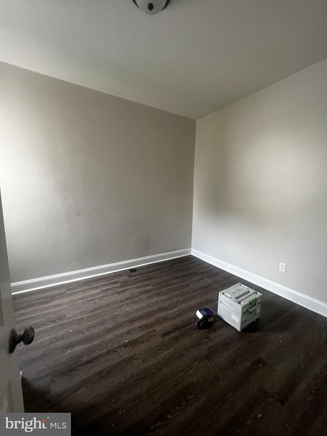 spare room featuring dark wood-type flooring