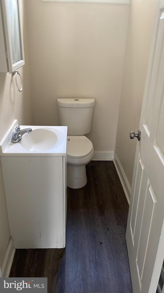 bathroom featuring wood-type flooring, toilet, and vanity